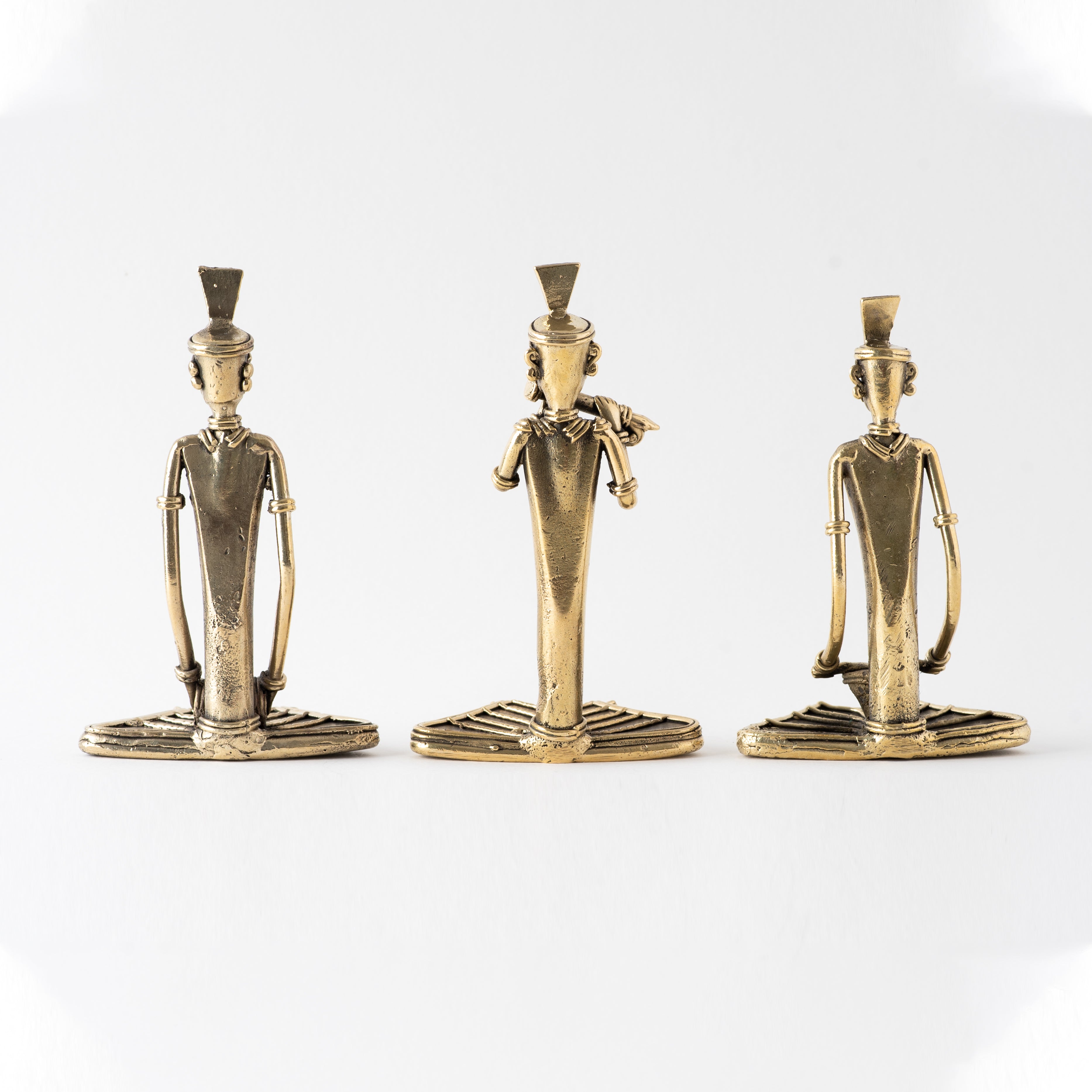 Four brass metal sculptures of sitting men 