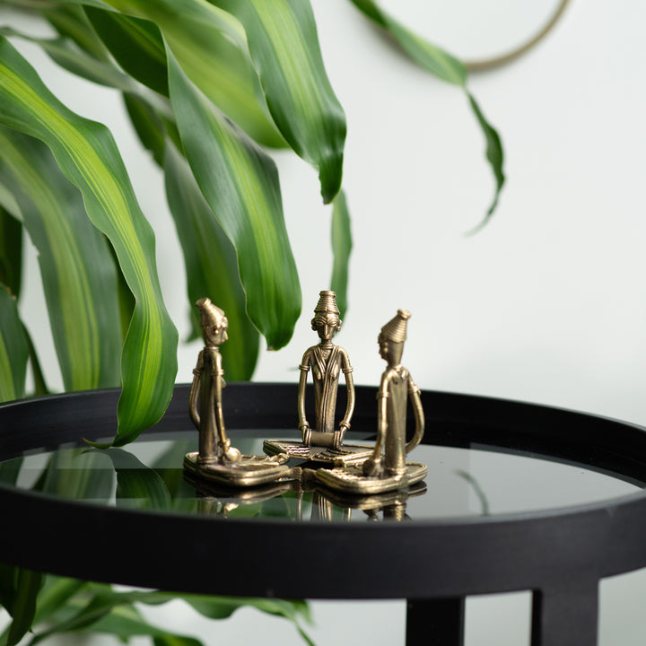 Three brass metal sculptures of sitting women musicians