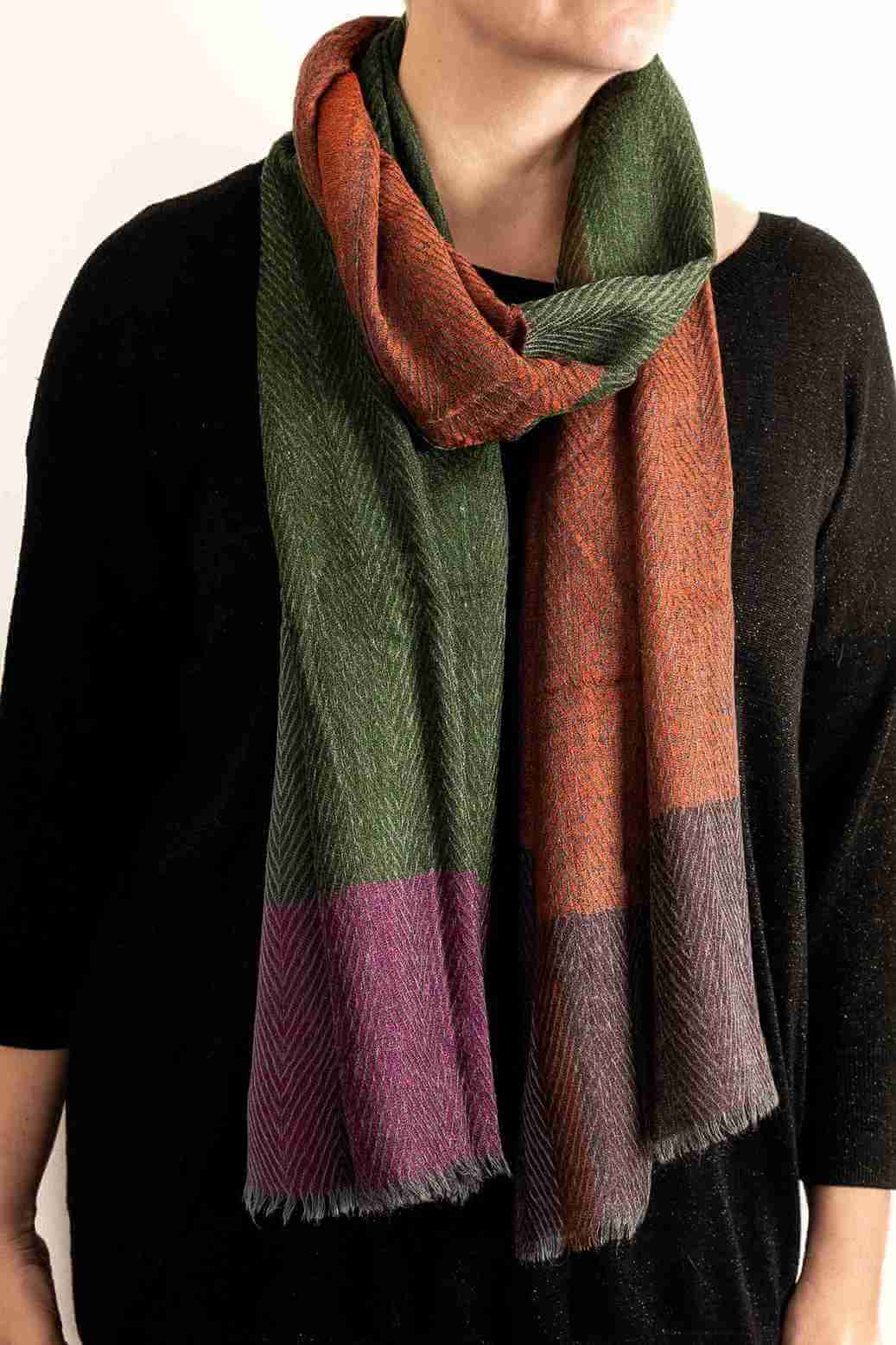 Person wearing a multicolored scarf with a black background