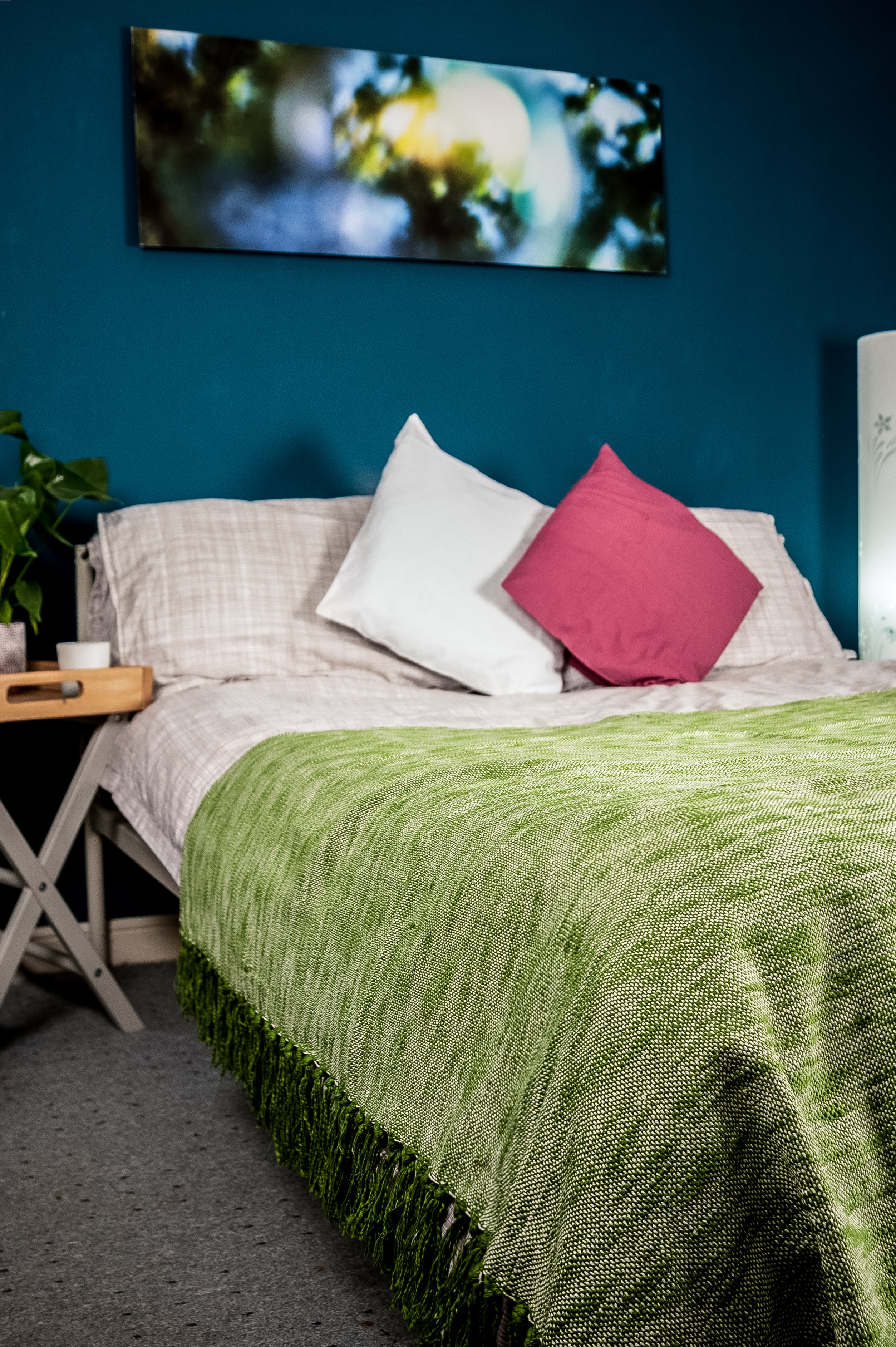 A subtle shade pink bedroom with a vibrant scenery board  in the background