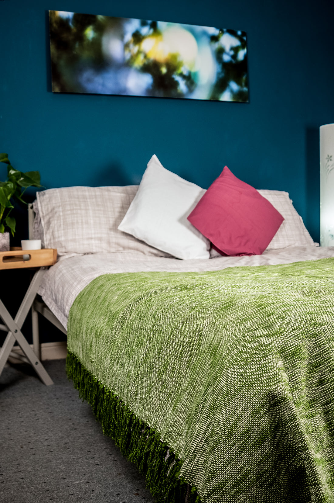A subtle shade pink bedroom with a vibrant scenery board  in the background