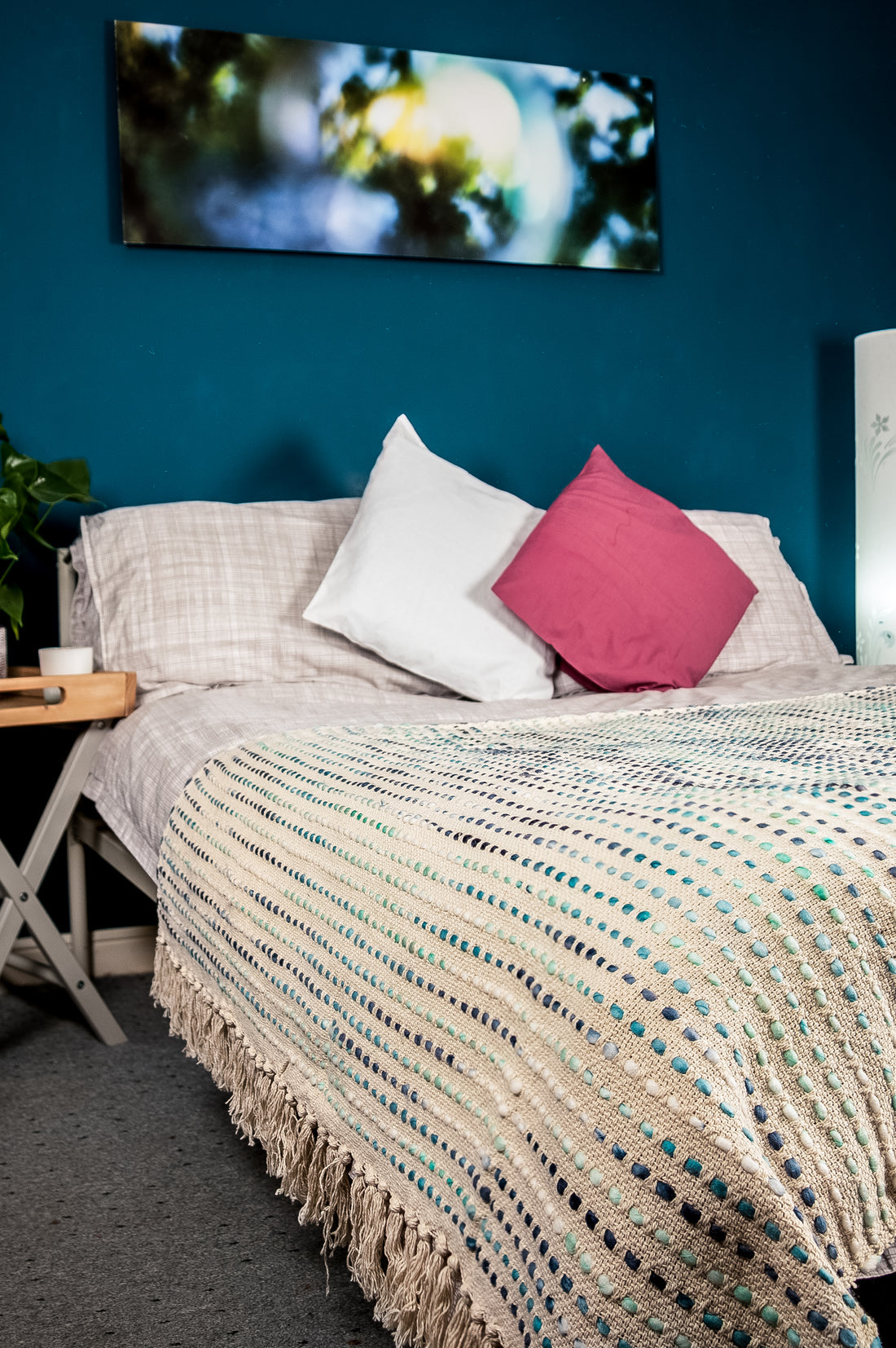 A subtle shade pink bedroom with a vibrant scenery board  in the background