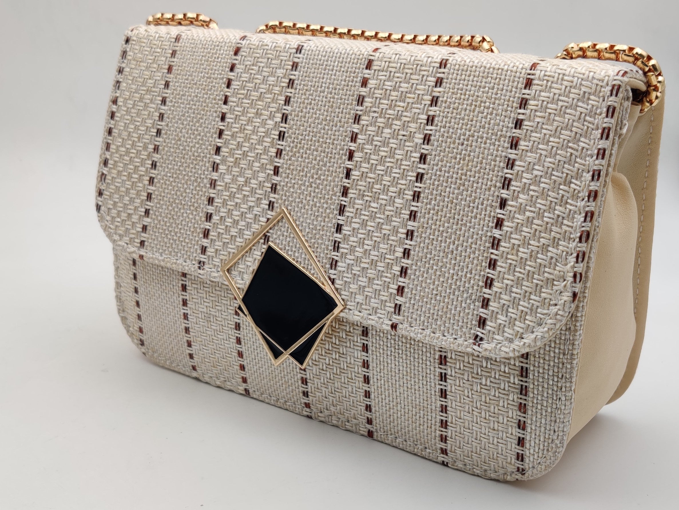 A beige handcrafted jute clutch bag with a geometric pattern.