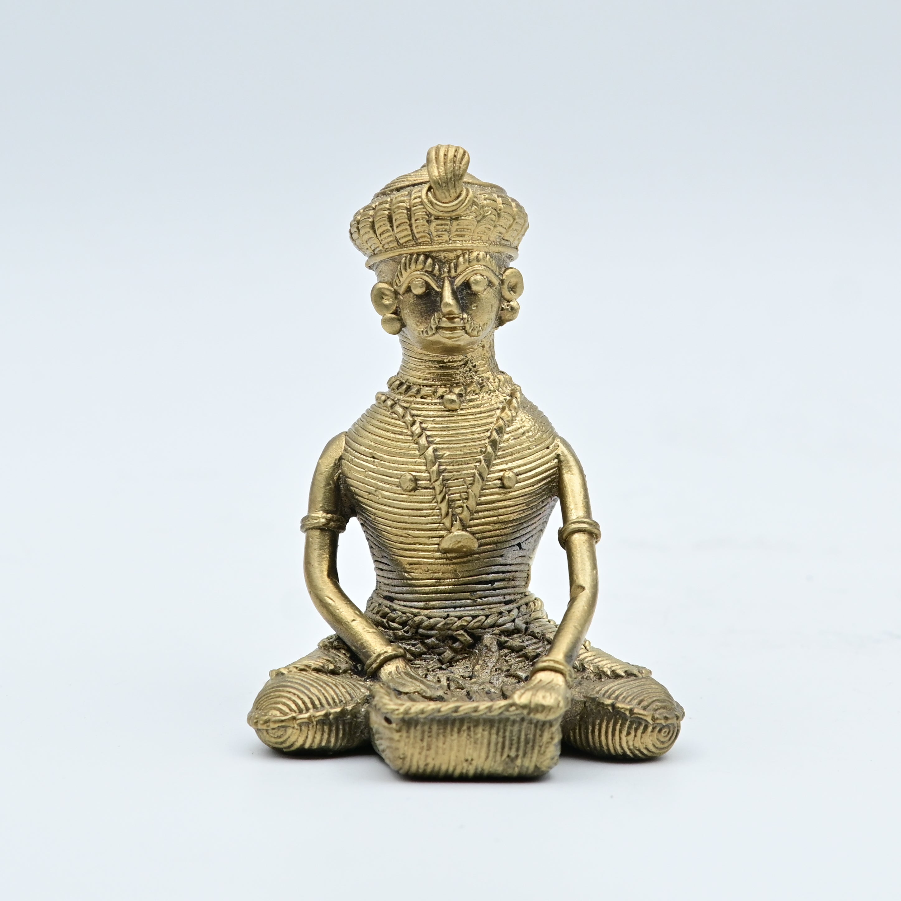 This item is a Dhokra brass statue depicting a traditional tribal musician or chieftain, created using the ancient lost-wax casting technique. 