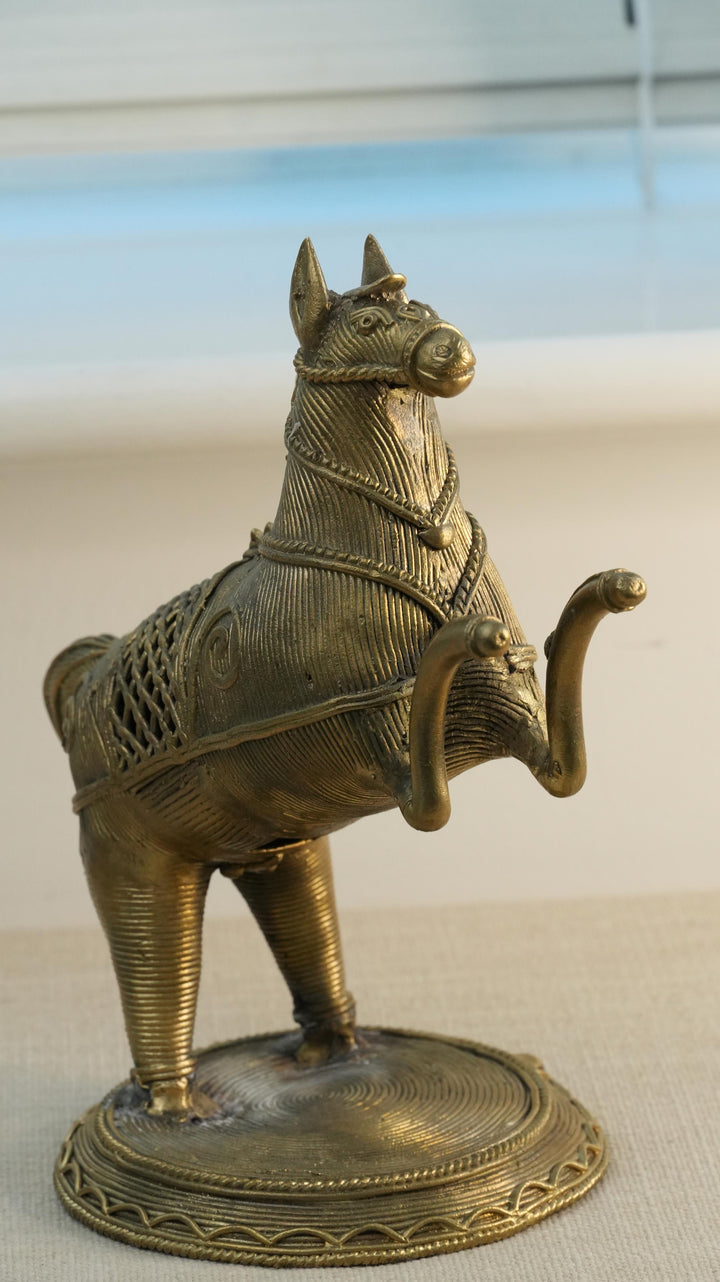 Bronze horse sculpture on a beige surface with a blurred background