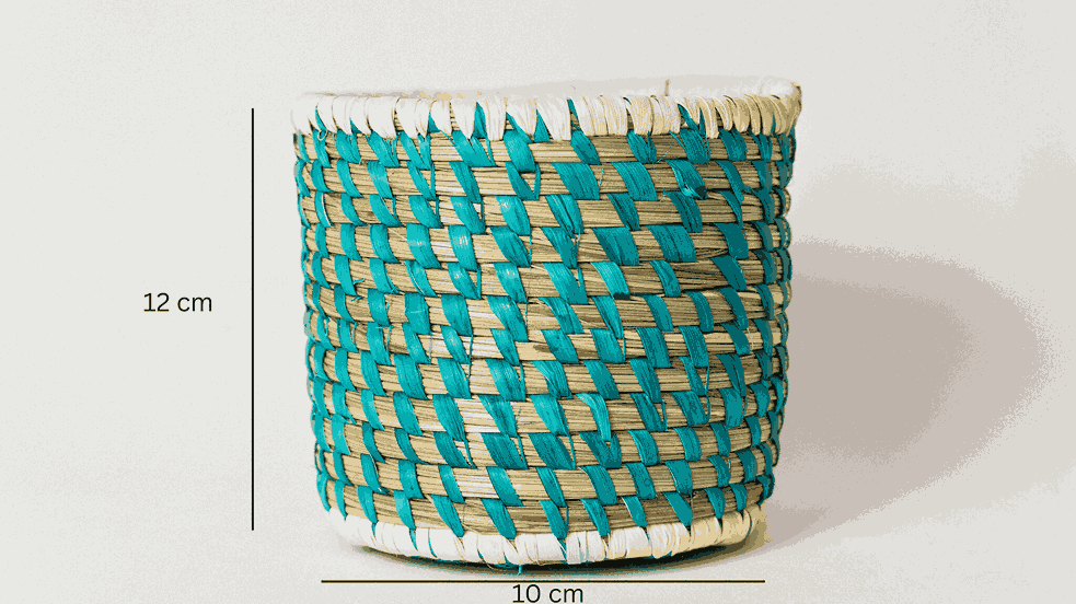 Woven basket with turquoise and beige pattern on a white background