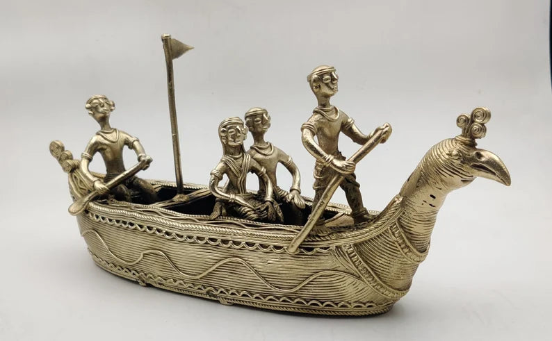 This item is a Dhokra brass handicraft figurine depicting a traditional Indian boat, often called a Mayurpankhi boat due to the peacock-shaped prow. 