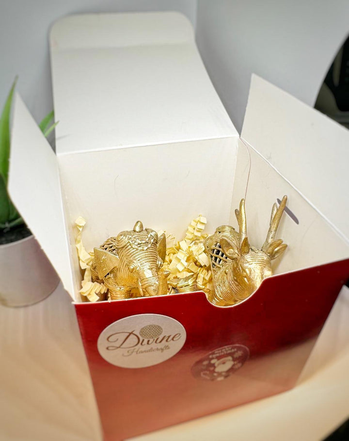 Open red and white box showcasing handcrafted golden animal figurines