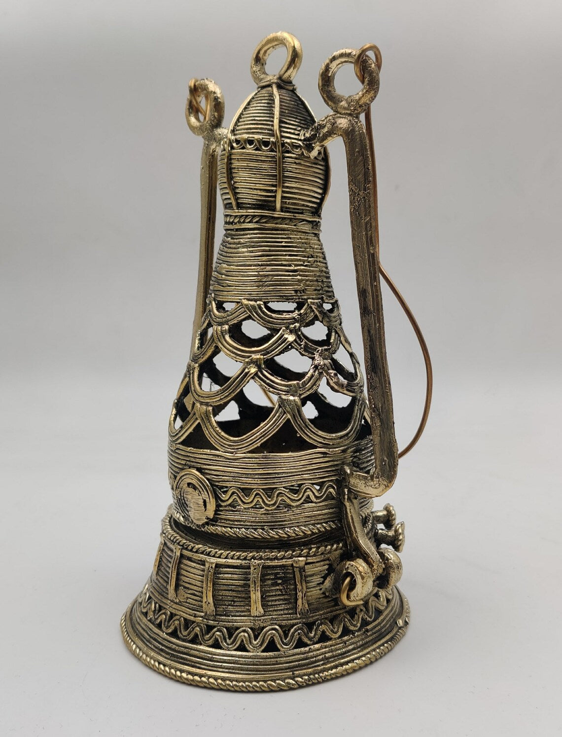 Handcrafted metal ornament featuring traditional Dhokra-style patterns