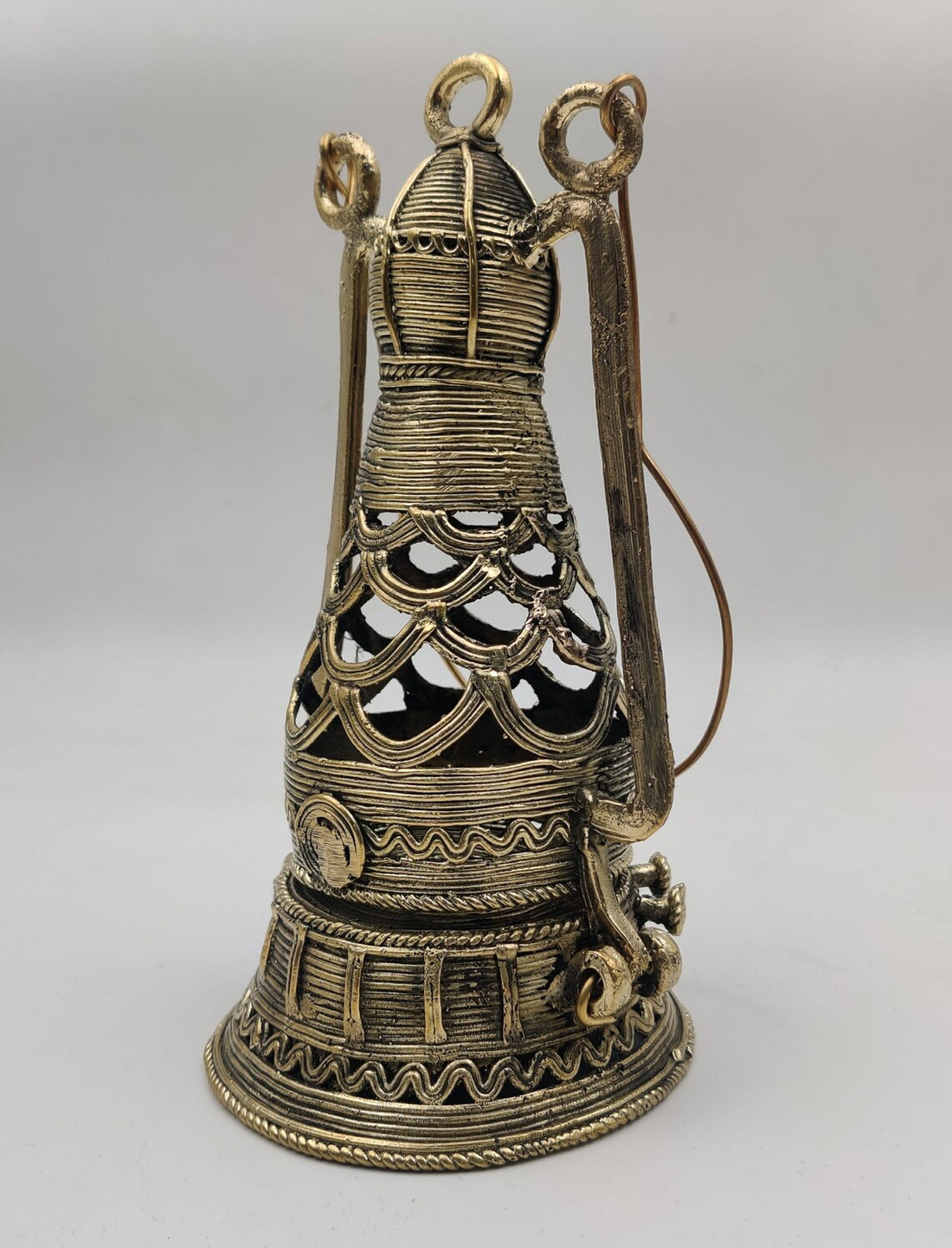 Handcrafted metal ornament featuring traditional Dhokra-style patterns