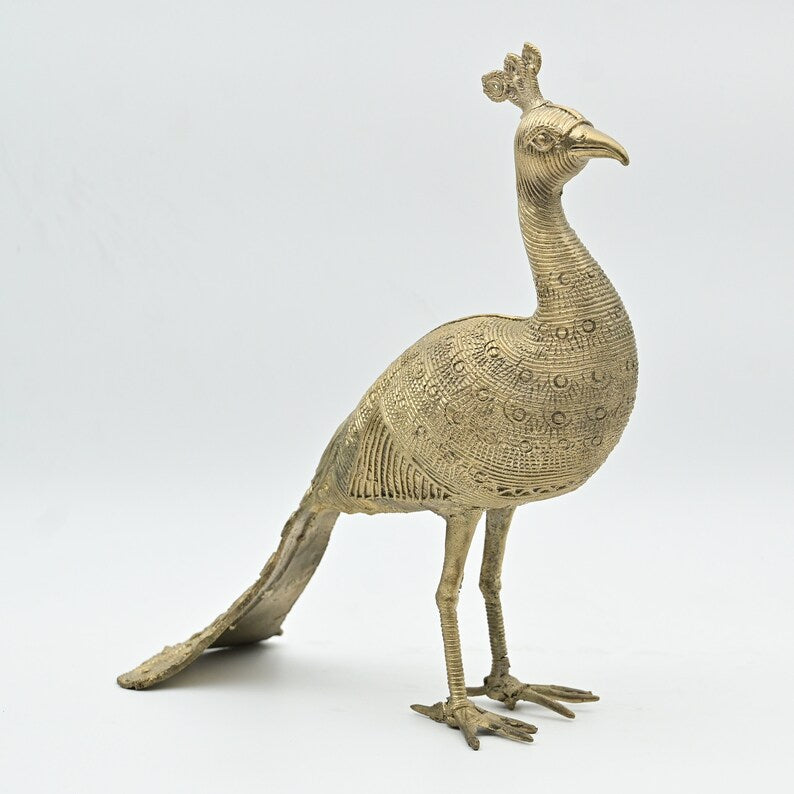 A handmade metal peacock statue with intricate brass detailing, featuring a vintage decorative design.