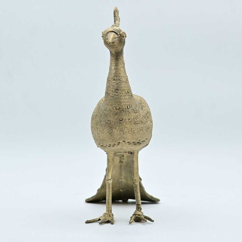 This item is a Dhokra metal peacock statue, a traditional form of Indian tribal art created using the lost-wax casting technique. 

