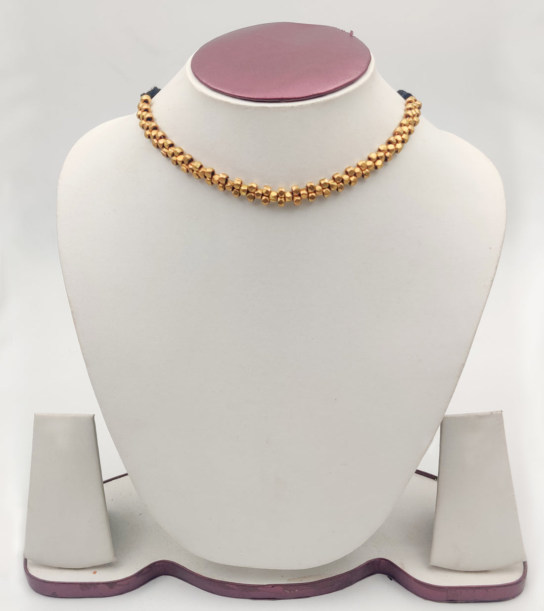 A vintage-style gold-colored single neck Sobour tribal jewellery necklace displayed on a mannequin bust.