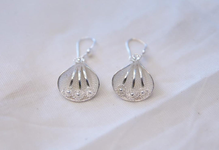 A pair of sterling silver filigree earrings with intricate lace-like patterns, displayed against a white background.