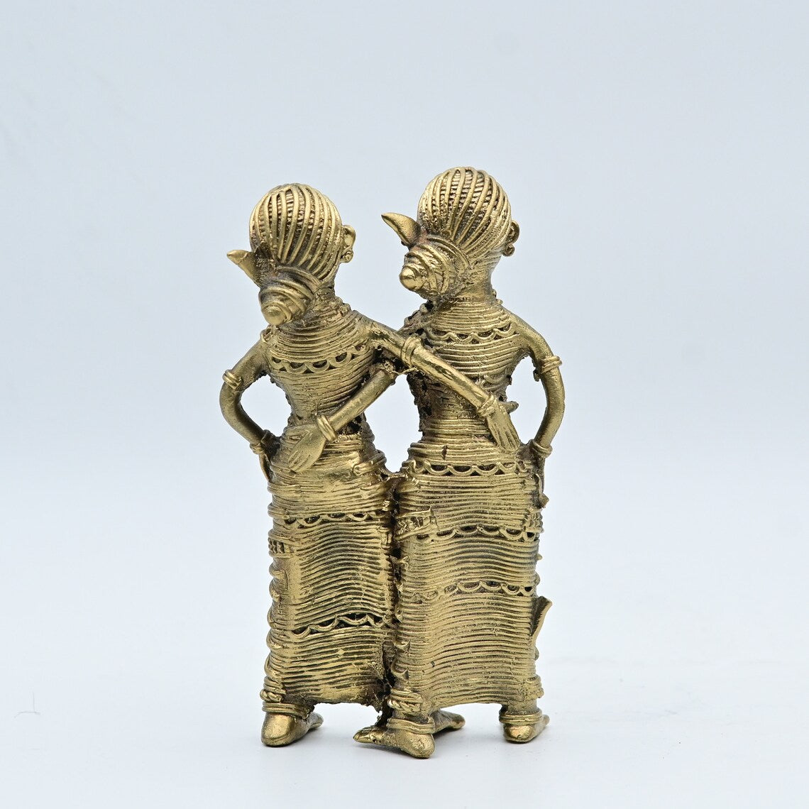 This item is a handcrafted Dhokra metal statue depicting a dancing tribal couple, representing a traditional art form from India. 