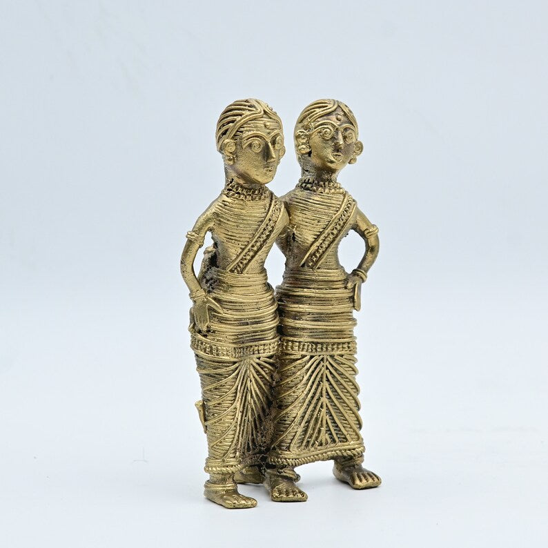 This item is a Dhokra tribal couple figurine, a traditional Indian brass metal craft made using the lost-wax casting technique. 
